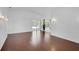 Bright open living room with sliding glass doors to outdoor space, plus neutral walls and hardwood floors at 307 Balmoral Ct, Davenport, FL 33896