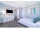 This bedroom features a clean design with a TV, white dresser, and light gray walls at 321 Lasso Dr, Kissimmee, FL 34747