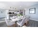 Chic dining area with a white table, grey chairs, and an open layout connecting to the modern kitchen and living space at 321 Lasso Dr, Kissimmee, FL 34747