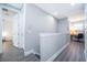 Upstairs hallway featuring gray walls and flooring with access to bedrooms and an office at 321 Lasso Dr, Kissimmee, FL 34747