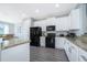 Bright kitchen with white cabinetry, granite countertops, and black appliances at 321 Lasso Dr, Kissimmee, FL 34747
