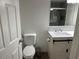 Well-lit bathroom with a single sink vanity, toilet, and tiled shower at 3301 Soho St # 104, Orlando, FL 32835
