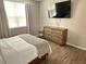 Comfortable bedroom featuring wood flooring and a wall-mounted television at 3301 Soho St # 104, Orlando, FL 32835
