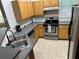 Features stainless steel appliances, wood cabinets, gray counters, and a double sink at 3301 Soho St # 104, Orlando, FL 32835