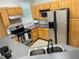 The kitchen features stainless steel appliances and gray countertops with wood cabinets at 3301 Soho St # 104, Orlando, FL 32835