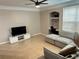 Living room with large grey sofa, tv, tile flooring, and built-in desk area at 3301 Soho St # 104, Orlando, FL 32835