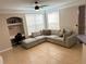 Open living room with a large couch, tile flooring, and a built-in desk area at 3301 Soho St # 104, Orlando, FL 32835