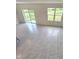 Bright living room with tile floors and large windows, offering a serene view of the outdoors at 3886 Whitney Way, Haines City, FL 33844