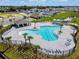 An aerial view of the community pool with clear blue water, cabana, and lounge chairs in a well-maintained space at 3886 Whitney Way, Haines City, FL 33844