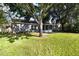 A view of the back of the house showing the patio, large yard and mature trees at 4215 Red Bird Ave, St Cloud, FL 34772