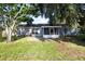 A view of the back of the house showing the patio, large yard and mature trees at 4215 Red Bird Ave, St Cloud, FL 34772