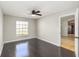 Bedroom features dark hardwood floors, a ceiling fan and a sunlit window at 4215 Red Bird Ave, St Cloud, FL 34772