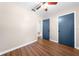 A bedroom with wood-look flooring, a ceiling fan, and blue doors leading to closets at 431 Eastern Ave, St Cloud, FL 34769