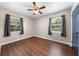 Cozy bedroom with wood-look flooring, ceiling fan, and natural light from two windows at 431 Eastern Ave, St Cloud, FL 34769