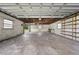 Spacious garage interior featuring concrete walls, open ceiling, and built in shelving at 431 Eastern Ave, St Cloud, FL 34769