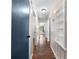 Hallway with wood-look floors, light walls, blue doors, and a built-in shelving unit at 431 Eastern Ave, St Cloud, FL 34769