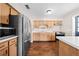 A well-lit kitchen with wood cabinets, stainless steel refrigerator, and laminate floors at 431 Eastern Ave, St Cloud, FL 34769