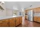 Open layout with kitchen featuring wood cabinets, stainless steel fridge, and view to the living room at 431 Eastern Ave, St Cloud, FL 34769