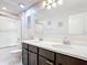 A bright bathroom features a double sink vanity, a large mirror and a glass enclosed shower at 4850 Coral Castle Dr, Kissimmee, FL 34746