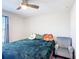 A cozy bedroom features a bed with decorative pillows, a fan, and a comfortable reading chair at 4850 Coral Castle Dr, Kissimmee, FL 34746