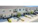 A row of modern townhomes, each with a driveway and neat landscaping in a Gathering-friendly community at 4850 Coral Castle Dr, Kissimmee, FL 34746