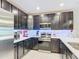Modern kitchen featuring dark cabinets, stainless steel appliances, and light countertops at 4850 Coral Castle Dr, Kissimmee, FL 34746