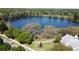 Aerial view of community lake, surrounded by mature trees, landscape, and community clubhouse at 5231 Lemon Twist Ln, Windermere, FL 34786