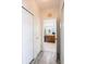 Hallway with wood floors leads to bathroom with double sink vanity and neutral color scheme at 5231 Lemon Twist Ln, Windermere, FL 34786