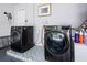 Convenient laundry room featuring modern washer and dryer units and updated tile flooring at 5231 Lemon Twist Ln, Windermere, FL 34786