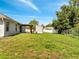 Backyard with lush green grass, a covered patio, and a trailer, providing a serene outdoor space at 640 Floridian Dr, Kissimmee, FL 34758