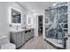 Modern bathroom with dual vanities, stylish mirrors, and a glass-enclosed shower featuring stone tile at 640 Floridian Dr, Kissimmee, FL 34758