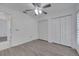 Bedroom with wood floors, ceiling fan, two closets, and open doorway leading to bathroom at 640 Floridian Dr, Kissimmee, FL 34758