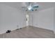 Bright bedroom with light gray hardwood flooring, white walls, and a blue ceiling fan at 640 Floridian Dr, Kissimmee, FL 34758