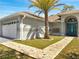 Close-up view of a single-story home with arched entryway and mosaic-tiled walkway at 640 Floridian Dr, Kissimmee, FL 34758