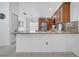View of kitchen featuring a granite countertop bar with brown wood cabinets and stainless appliances at 640 Floridian Dr, Kissimmee, FL 34758