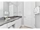 Bright bathroom featuring a large mirror over double vanity with stone countertop and white cabinets at 7770 Sandy Ridge Dr # 142, Kissimmee, FL 34747