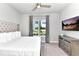 Bright bedroom features a large window, stylish dresser and a comfortable bed with tufted headboard at 7770 Sandy Ridge Dr # 142, Kissimmee, FL 34747