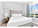 This bright bedroom features a plush bed with tufted headboard and a view to the outside at 7770 Sandy Ridge Dr # 142, Kissimmee, FL 34747