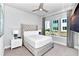 Comfortable bedroom with a large window, ceiling fan, upholstered headboard, and wall mounted television at 7770 Sandy Ridge Dr # 142, Kissimmee, FL 34747