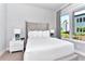 Inviting bedroom with a large window, modern decor, upholstered headboard, and stylish bedside lamps at 7770 Sandy Ridge Dr # 142, Kissimmee, FL 34747