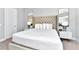 Spacious bedroom with a tufted headboard, ample lighting, and minimalist decor at 7770 Sandy Ridge Dr # 142, Kissimmee, FL 34747
