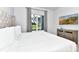 Bright bedroom features a large window, stylish dresser, wall-mounted TV, and a comfortable tufted bed at 7770 Sandy Ridge Dr # 142, Kissimmee, FL 34747