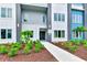 Close-up view of a three-story condo featuring a sidewalk, landscaping, and a sleek modern design at 7770 Sandy Ridge Dr # 142, Kissimmee, FL 34747