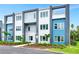 Modern three-story townhome featuring colorful facades and manicured landscaping for enhanced curb appeal at 7770 Sandy Ridge Dr # 142, Kissimmee, FL 34747