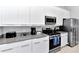 Sleek kitchen features stainless steel appliances, ample counter space, and modern white cabinetry at 7770 Sandy Ridge Dr # 142, Kissimmee, FL 34747