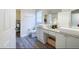 Well-lit bathroom featuring double sinks, granite counters, and wood-look floors at 8121 Fan Palm Way, Kissimmee, FL 34747