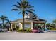 Community center with stone columns, covered entryway, and well-maintained landscaping at 8121 Fan Palm Way, Kissimmee, FL 34747