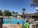 Resort-style community pool featuring families swimming, lounge chairs, and palm trees at 8121 Fan Palm Way, Kissimmee, FL 34747