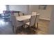 Modern dining room features a sleek white table and six upholstered chairs at 8121 Fan Palm Way, Kissimmee, FL 34747