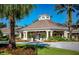 Well-maintained clubhouse with manicured landscaping and a circular driveway at 8121 Fan Palm Way, Kissimmee, FL 34747